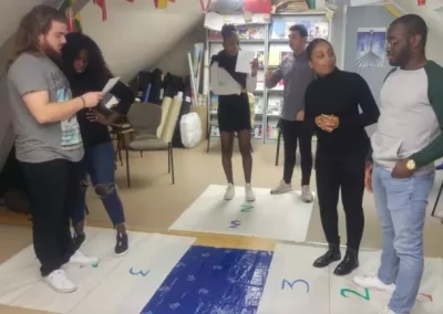 Des personnes participent à une activité de groupe sur un tapis numéroté.