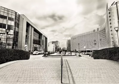 Rue bordée de bâtiments modernes sous un ciel nuageux, perspective centrale.